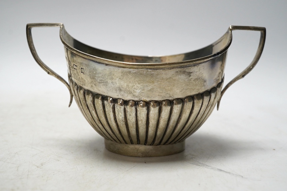 A matched late 19th/early 20th century demi-fluted silver three piece tea set, London, 1884 and later, gross weight 15.5oz. Condition - poor to fair